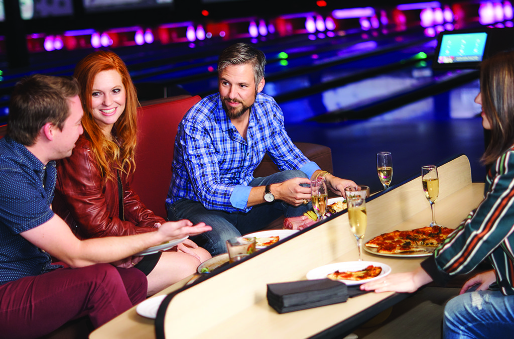 Friends eating at an upscale bowling alley
