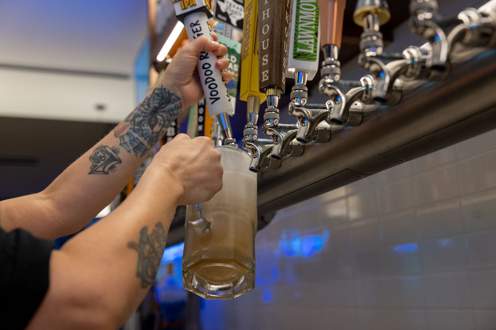 Image of a bartender pouring a Voodoo Craft Beer from draft at happy hour. 