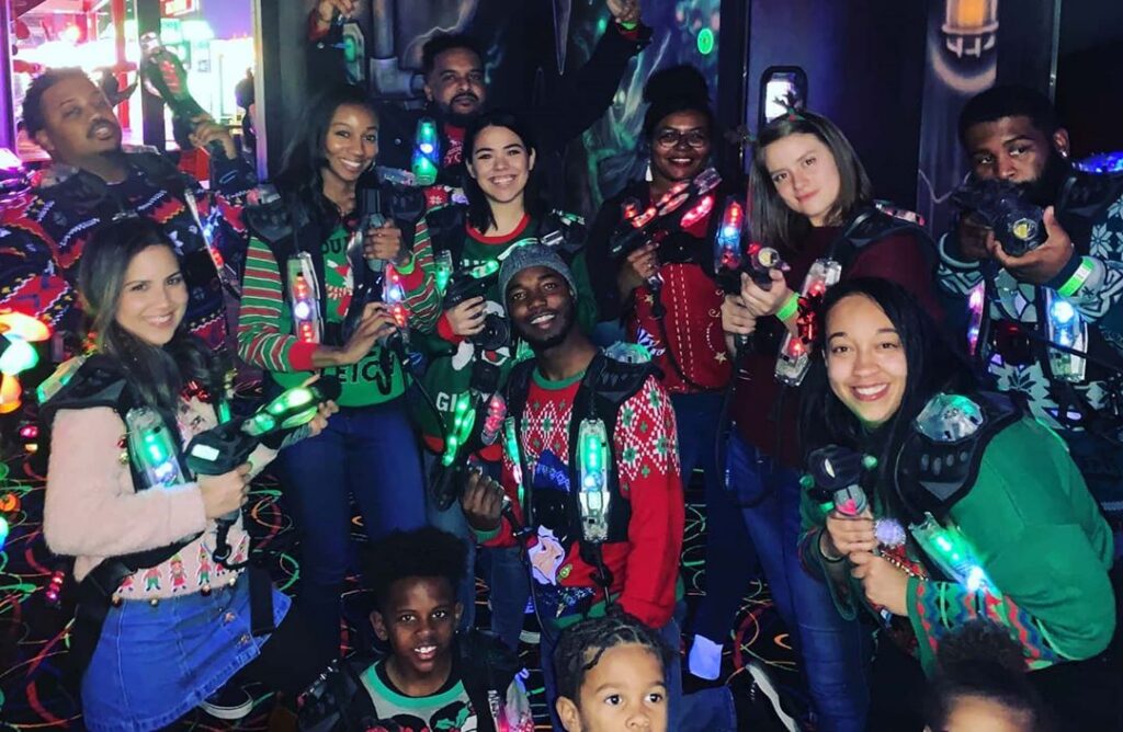 Photo of a family reunion group in ugly Christmas sweaters playing Laser Tag.