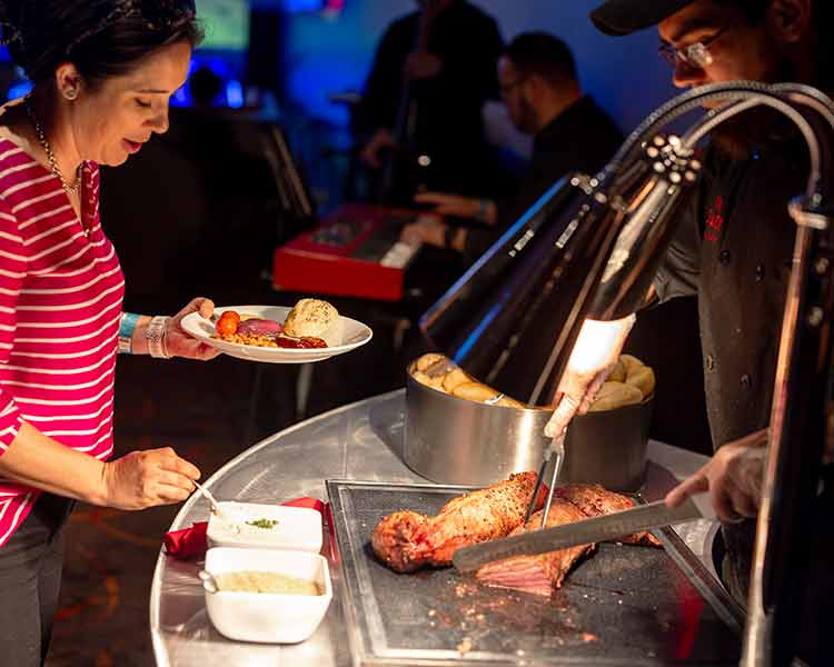 Image of a group event culinary Team Member carving prime tenderloin for a group guest.