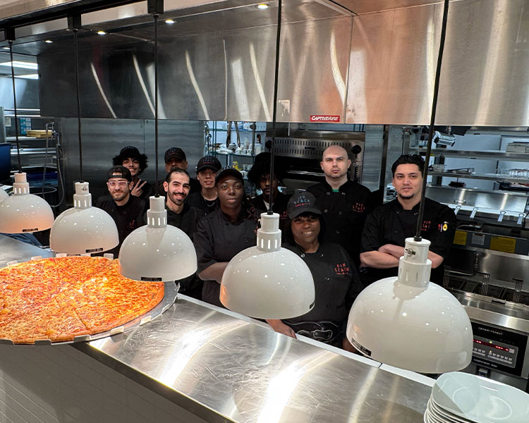 Image of Culinary Team posing in kitchen with a KingPin Pizza