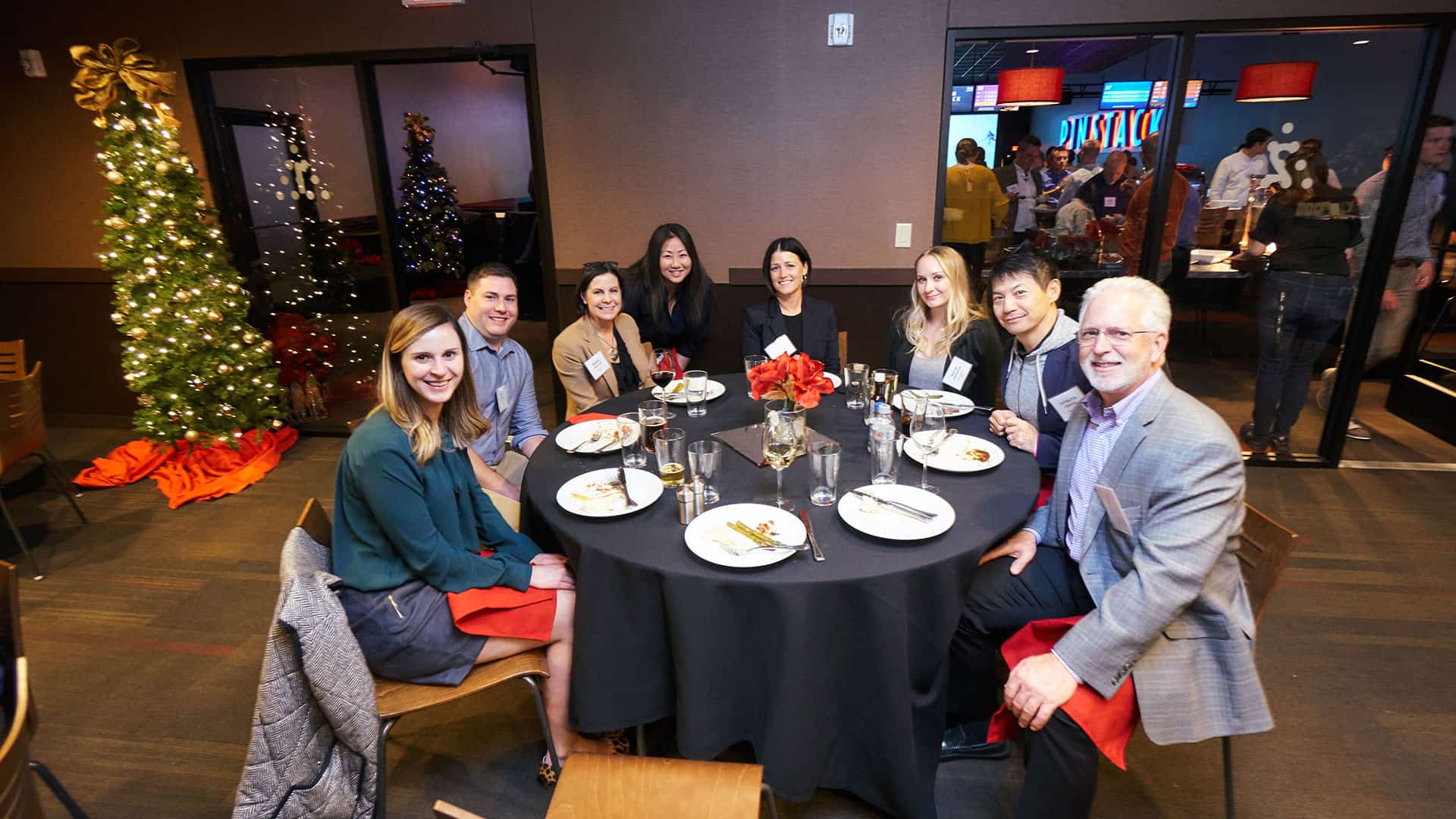 A photo of a group of employees at a holiday party enjoying a catered buffet in the private event room at Pinstack.